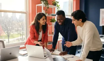 Drie diverse professionals werken samen aan een lichte moderne werkplek met laptops en notitieboeken, warm natuurlijk licht.